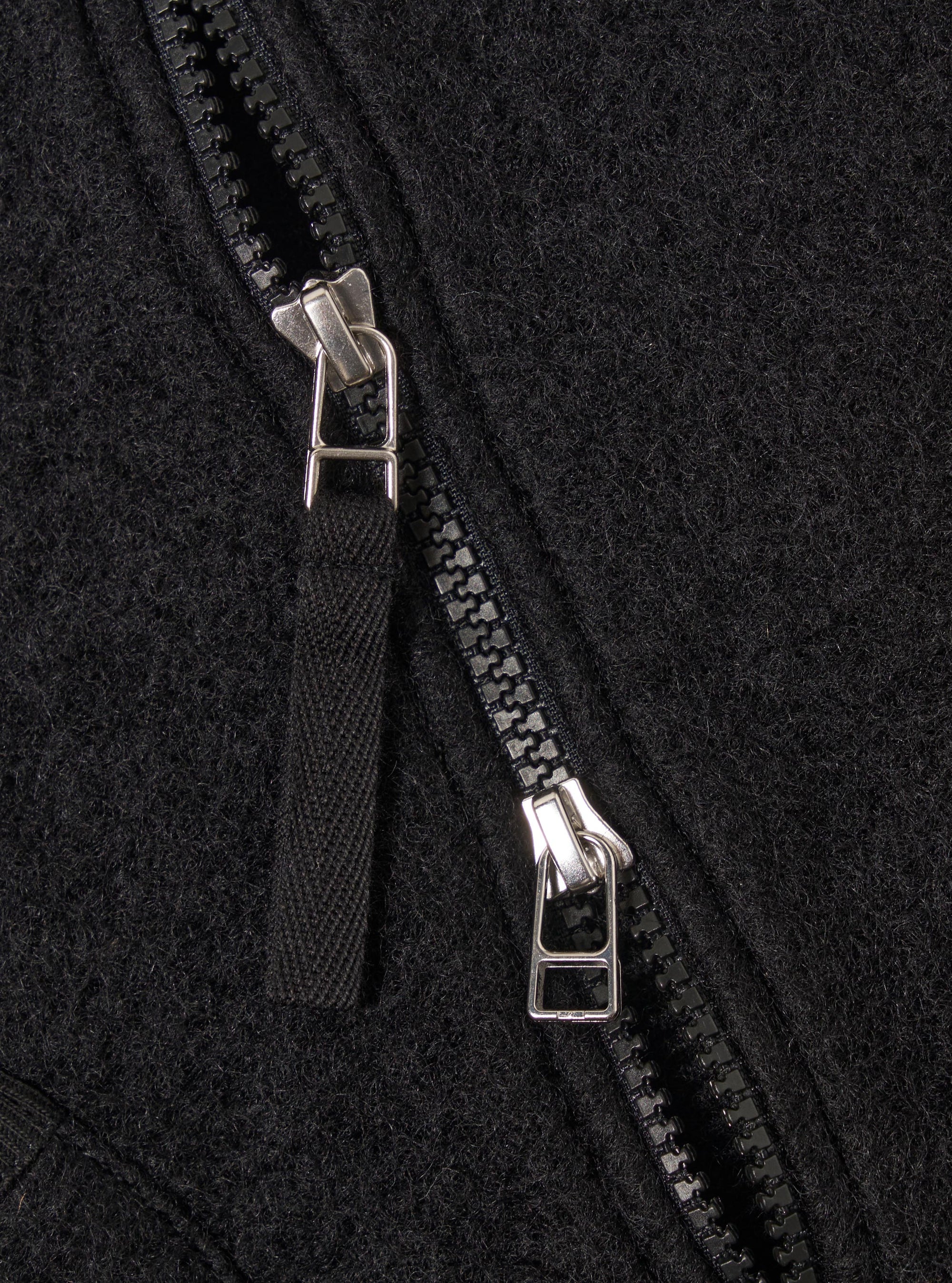 Close-up of the Black Wool Fleece Zip Waistcoat, showcasing the texture of the black wool fleece and the zipper detail. The image is tightly cropped.