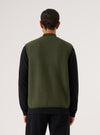 Back view of a model wearing an Olive Wool Fleece Zip Waistcoat. The olive green wool vest is layered over a black long-sleeve shirt. Shot against a white backdrop.