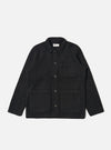 The Black Wool Fleece Field Jacket, made of black wool fleece, is laid flat on a white background. It features a collared neck, button closure, and multiple pockets.