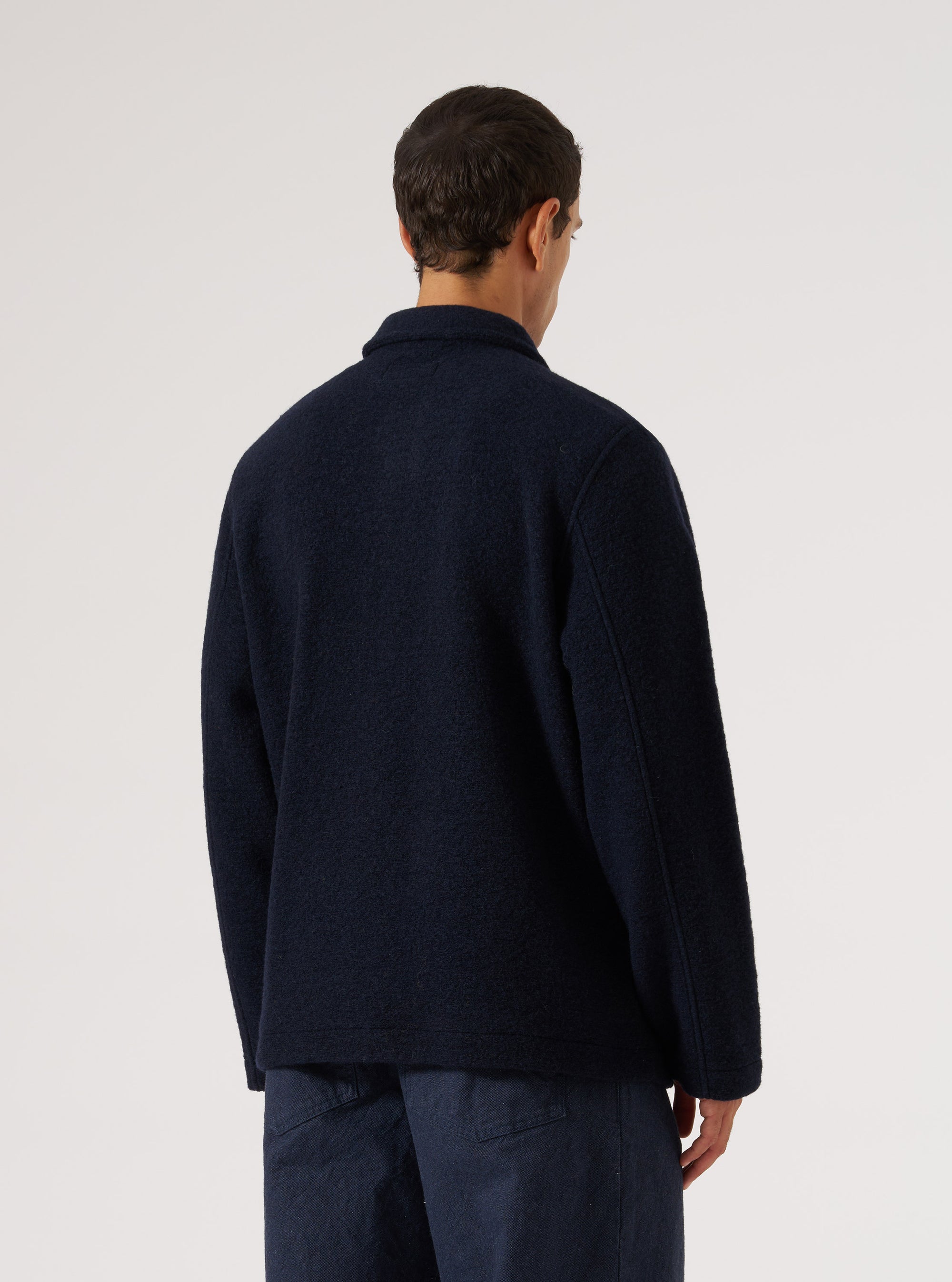Back view of a model wearing the Navy Wool Fleece Field Jacket. The jacket is a dark navy color and made of a wool fleece material. The background is a plain white.