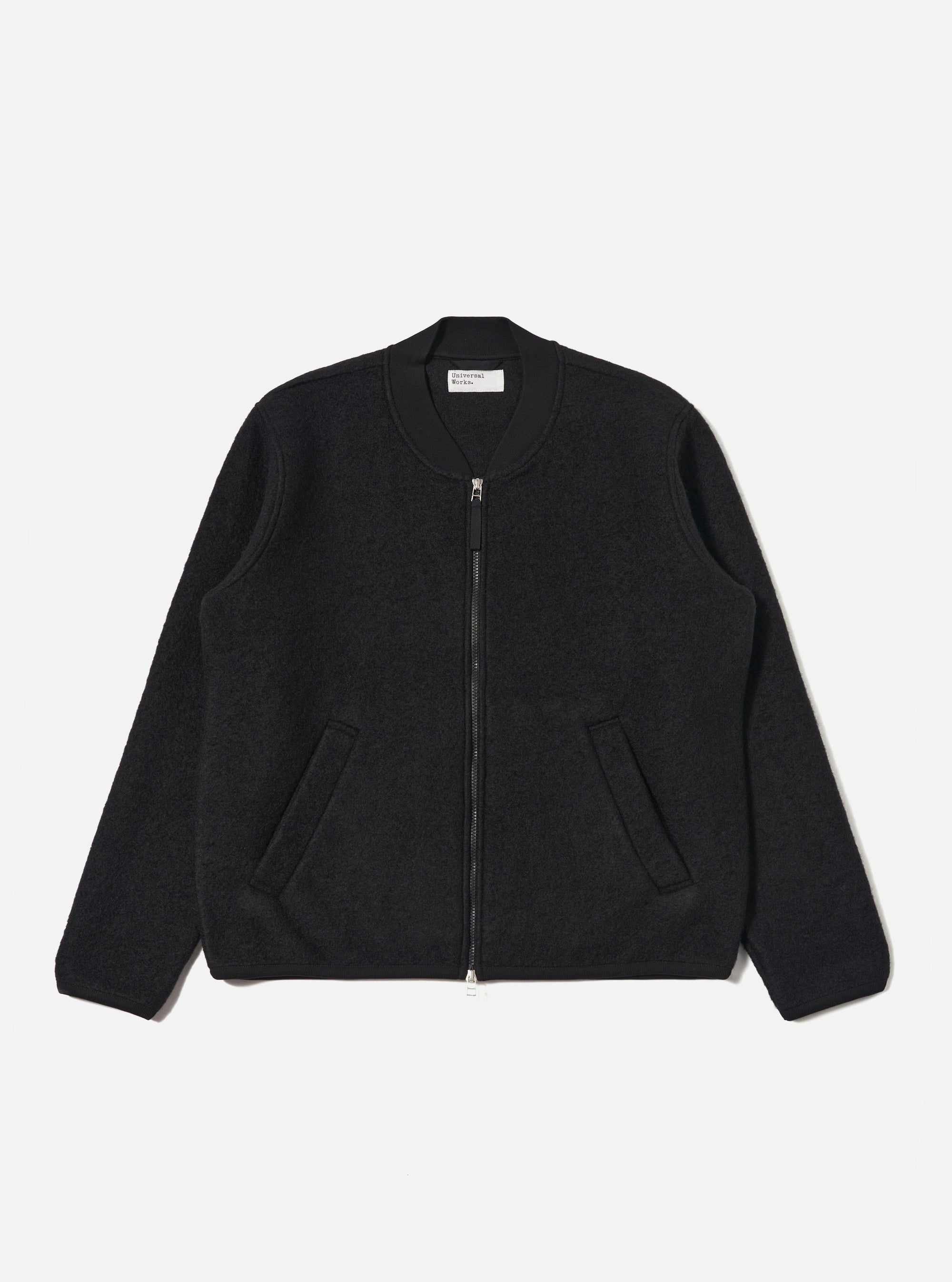 The Black Wool Fleece Zip Bomber is displayed on a white background. The bomber is black, made of wool fleece, and has a zip closure. It features a classic fit.