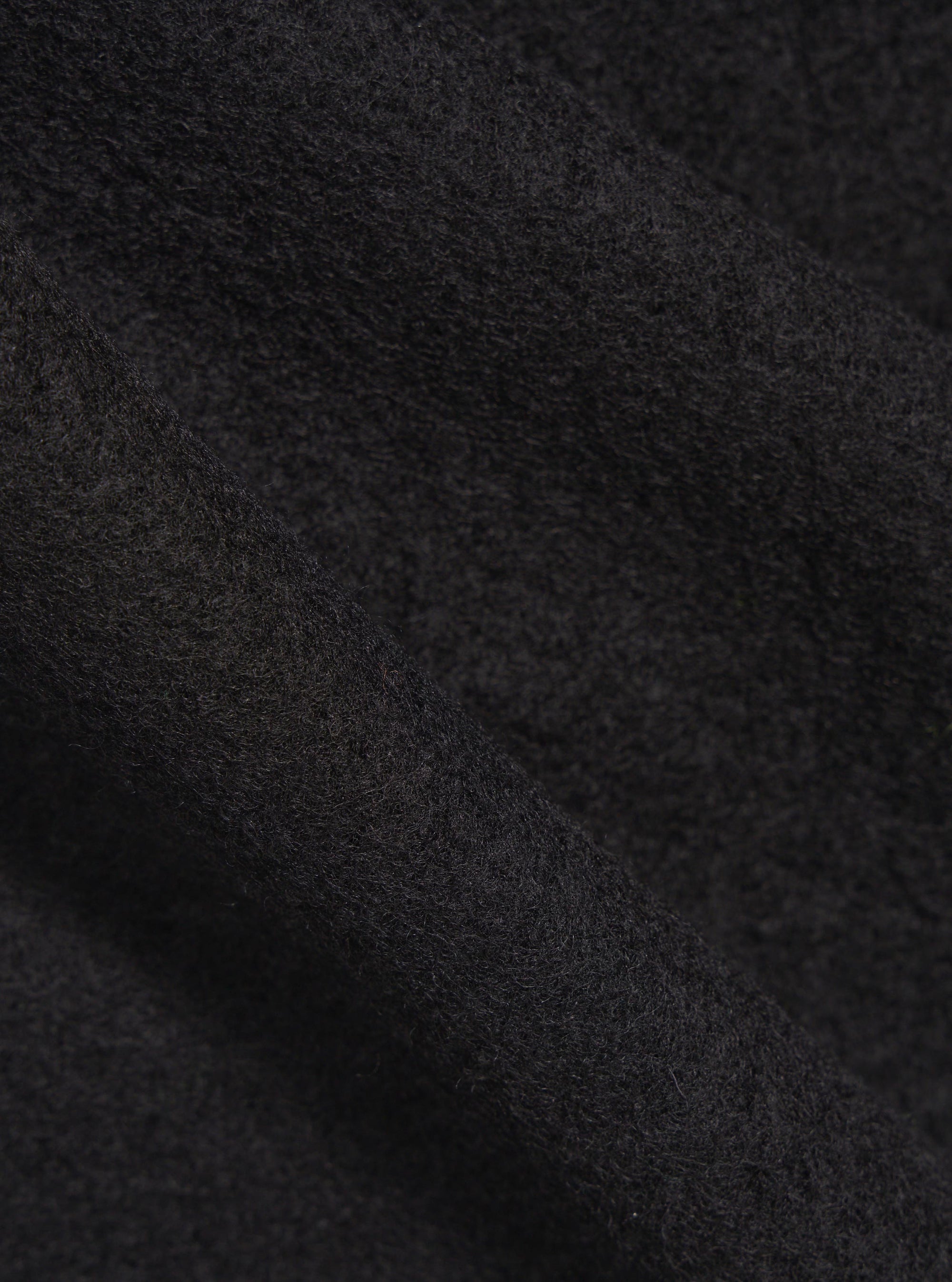 Close-up of the Black Wool Fleece Zip Bomber fabric. Soft, dark wool texture. Great for a warm, stylish jacket.