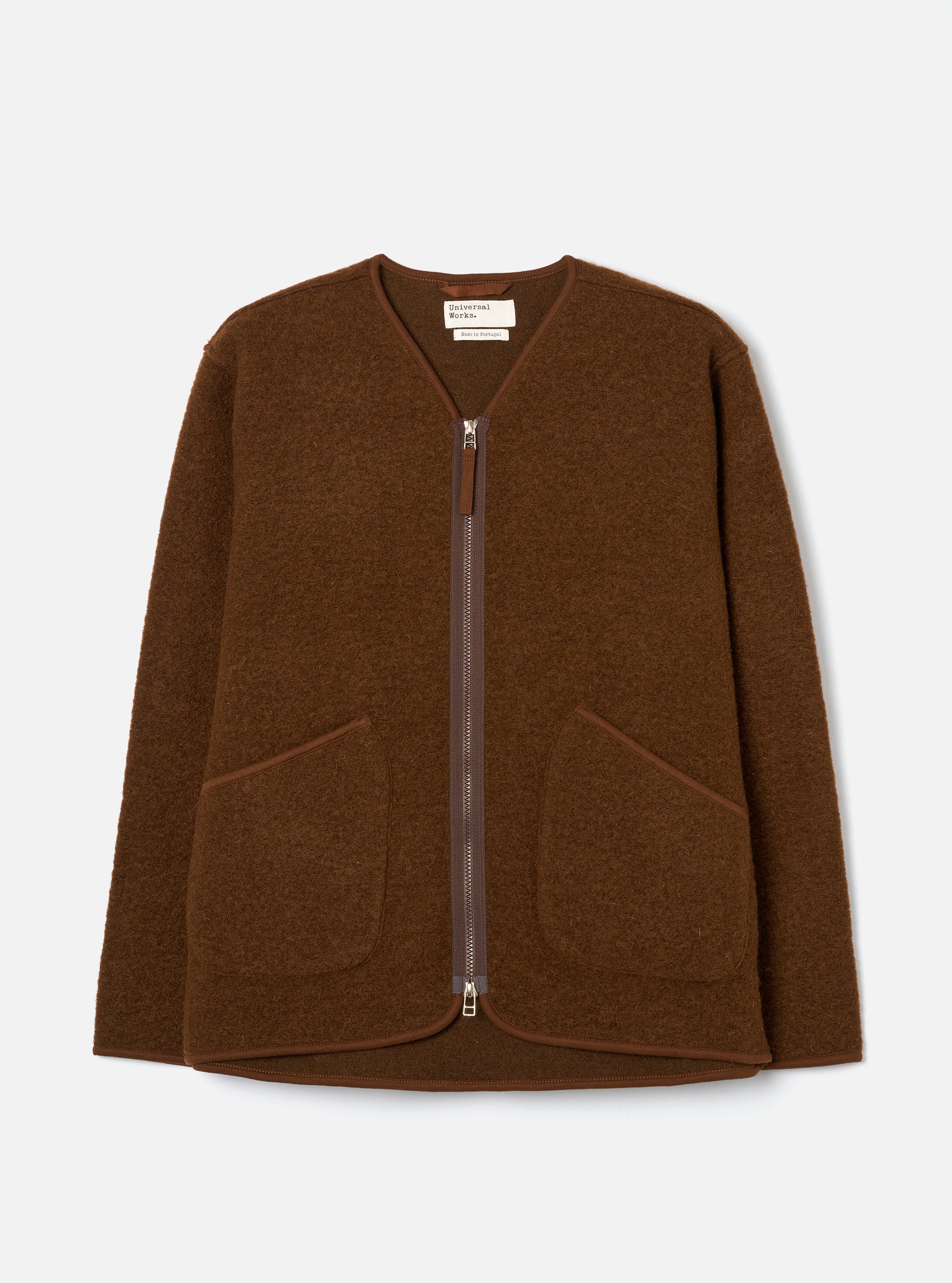 Cacao brown wool fleece zip liner jacket laid flat on a light grey studio backdrop. Collarless V-neckline with tonal bound edging, full-length silver metal zip, and two patch pockets at the lower front. Textured boiled wool fleece fabric throughout. Universal Works woven label visible at the neck.
