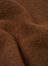 Close-up detail shot of the cacao wool fleece fabric used in the zip liner jacket. The texture shows a dense, brushed surface with visible individual fibres in a warm brown tone. Soft folds in the fabric highlight the plush, fluffy pile and the depth of the fleece.