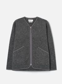 Grey marl wool fleece zip liner jacket, flat lay on a light grey seamless backdrop. Collarless V-neckline with tonal bound edges running down the full-length centre-front zip, which has silver metal pulls at top and bottom. Two large angled welt pockets at the lower front with matching bound trim. Textured boiled wool fleece fabric throughout.