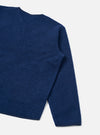 Close-up of an indigo wool fleece zip liner jacket on a plain light grey studio backdrop. The shot shows the upper chest, one shoulder and a full sleeve, cropped at the hem. The boiled wool fleece texture is visible across the body and sleeve, with a narrow bound cuff edge and a patch pocket partially visible at the lower left.