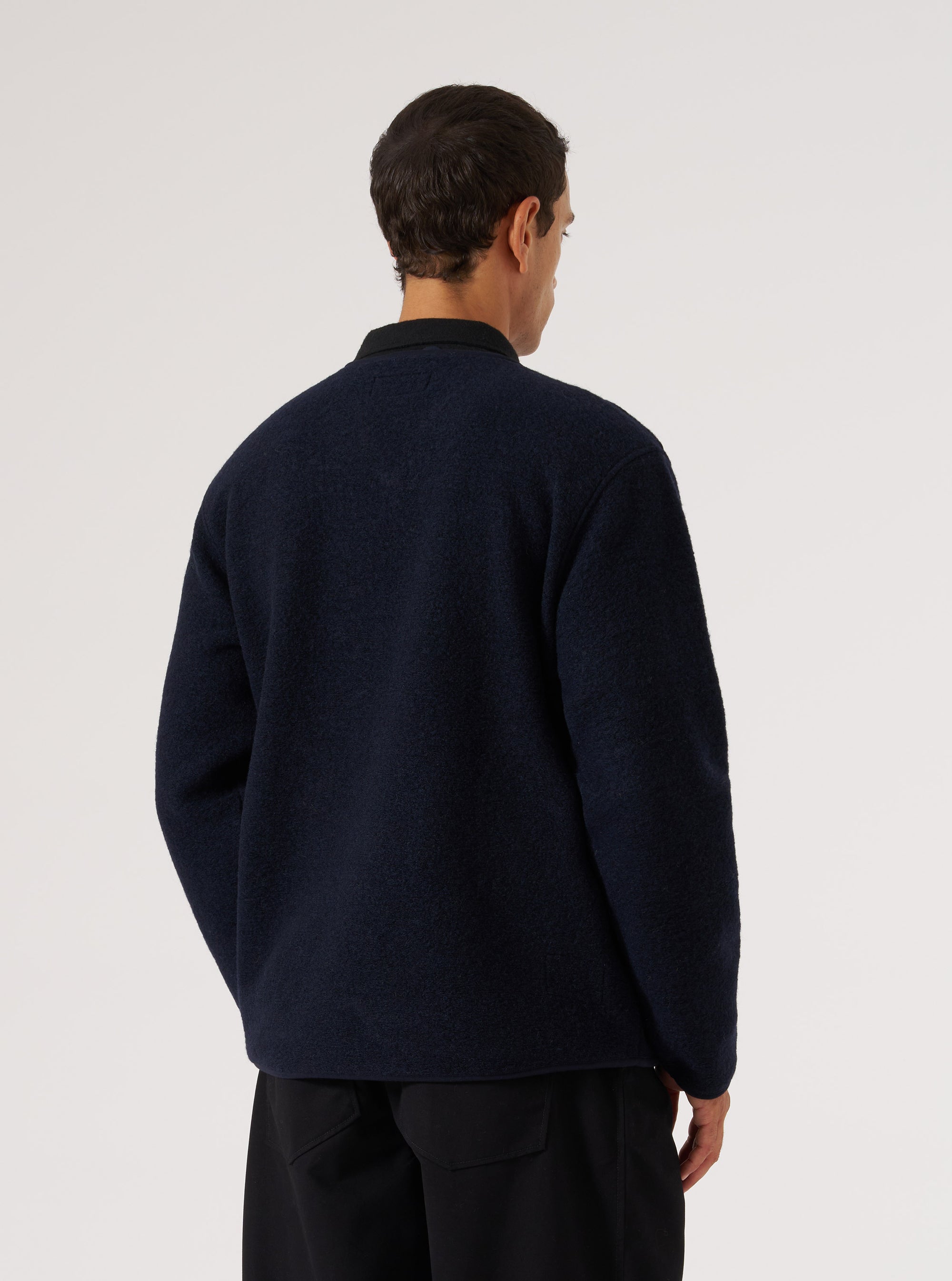 Back view of a model wearing a Navy Wool Fleece Zip Liner Jacket. The jacket is navy blue, wool fleece, and the background is a plain white.
