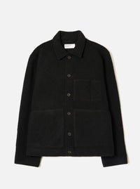 Black wool fleece uniform jacket laid flat on a white studio backdrop. Features a point collar, five dark buttons down the centre front, one chest patch pocket and two large lower patch pockets. The textured boiled wool fleece fabric is visible throughout. A Universal Works woven label sits inside the collar.
