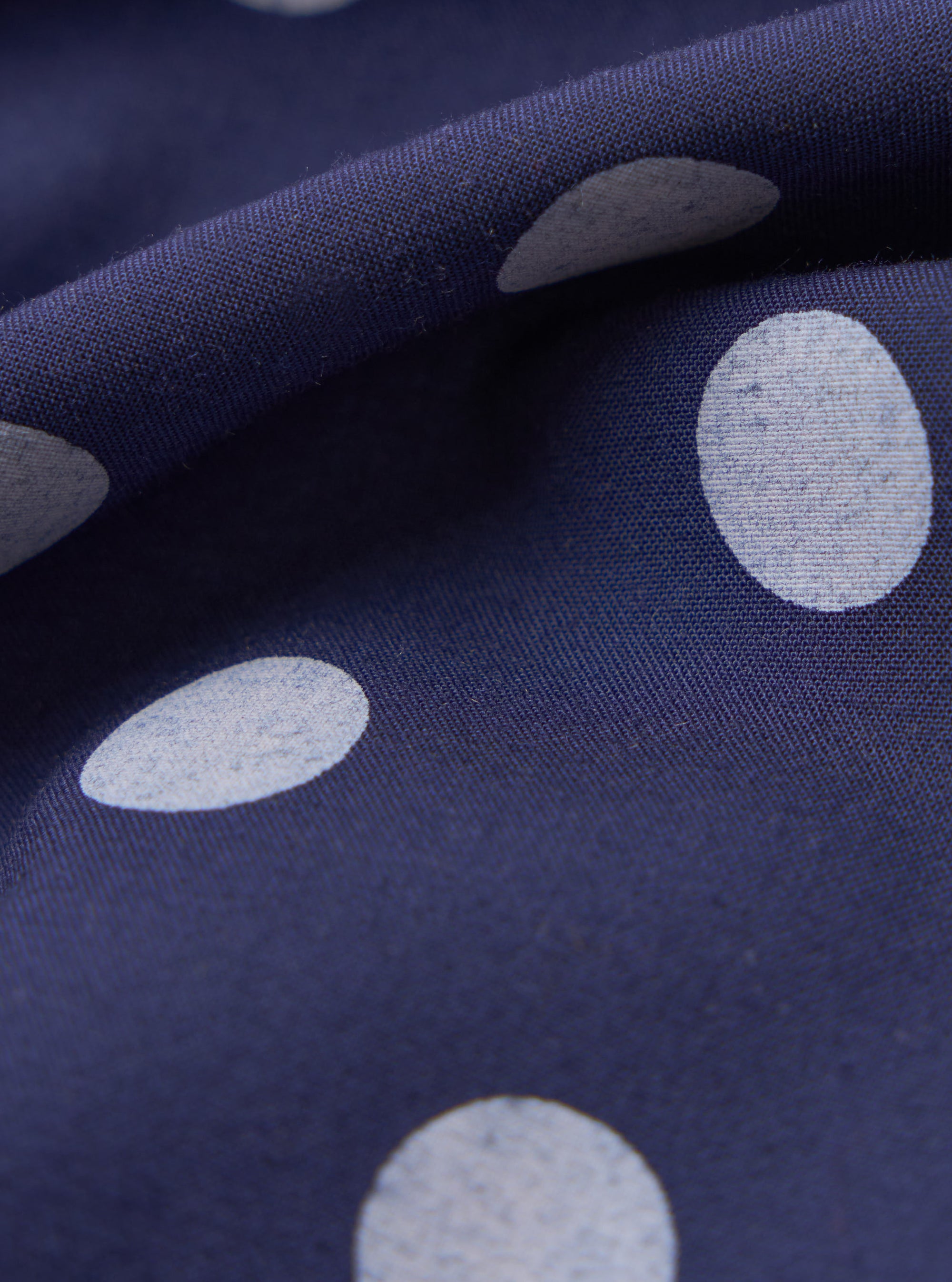 Close-up of the Navy Bold Dot Print Rayon Scout Scarf, showing the fabric's texture and the bold white polka dot pattern on the navy background.