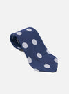 The Navy Bold Dot Print Rayon Tie on a white surface. The tie is navy with white dots. The tie is rolled up to show the pattern.