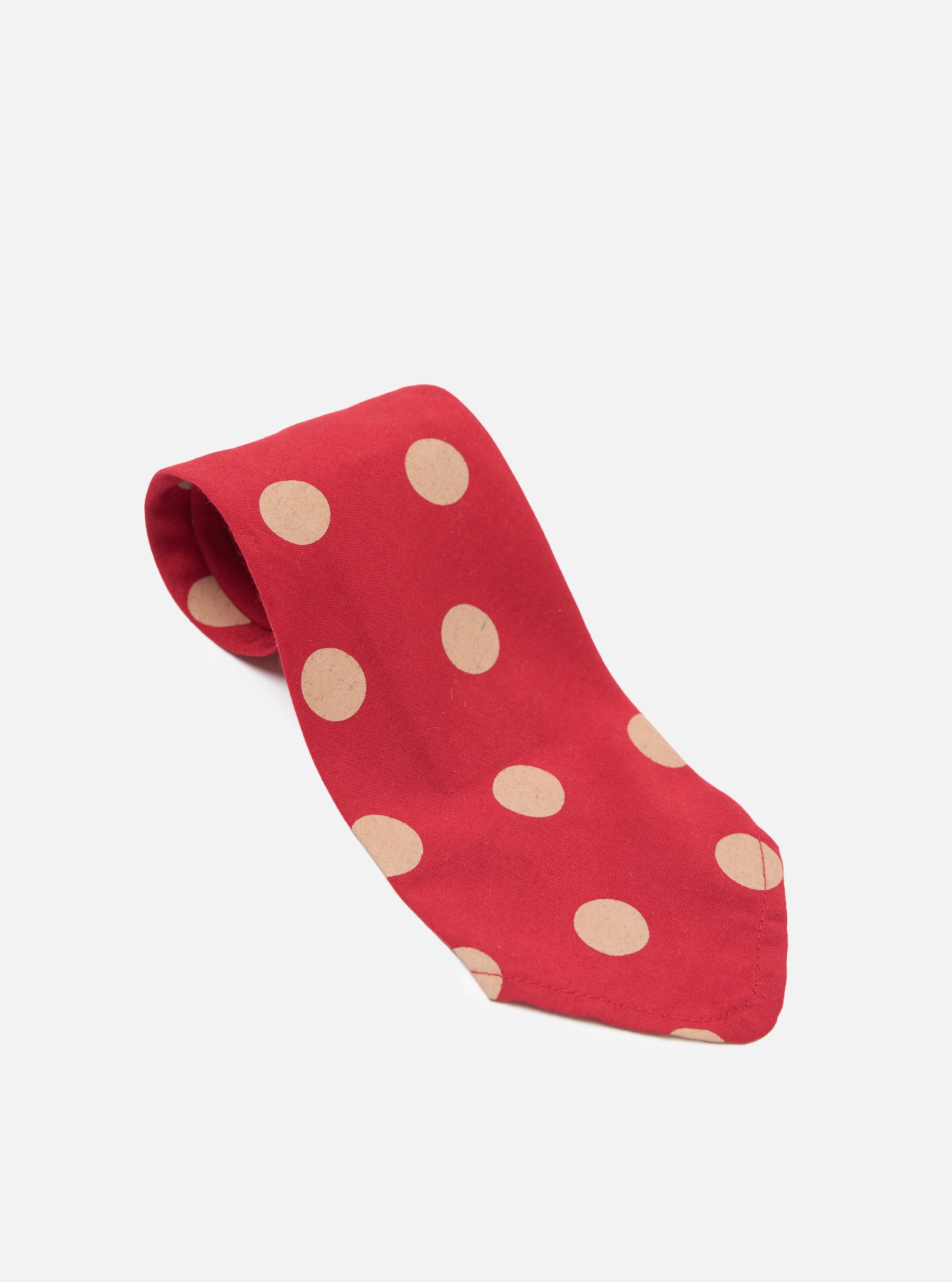 Close-up of a Red Bold Dot Print Rayon Tie on a white surface. The tie features large tan polka dots and is made of soft rayon fabric.