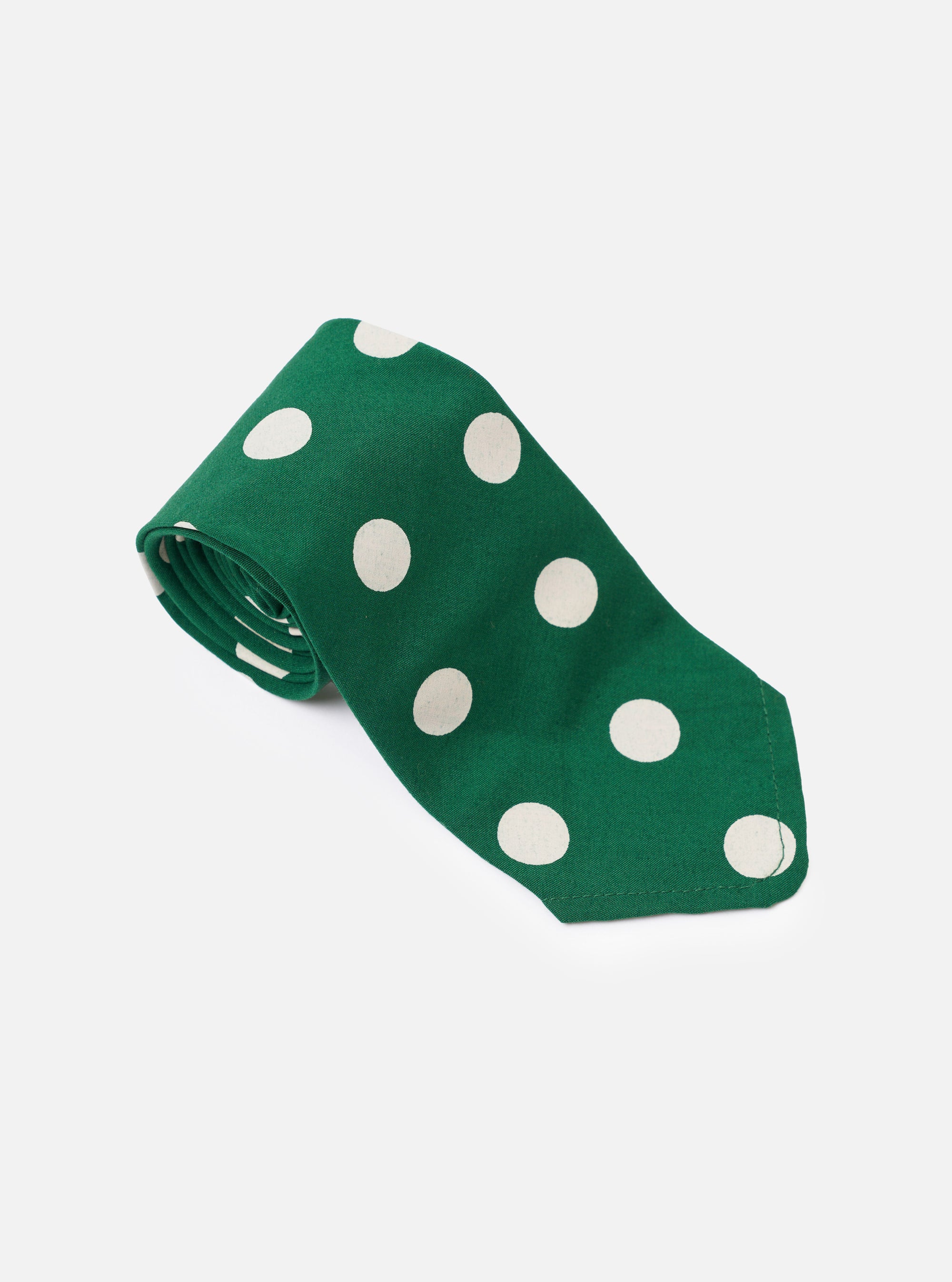 The Forest Green Bold Dot Print Rayon Tie is shown from a rear view as a flat lay against a plain white background. The image highlights the construction of the tie, including the keeper loop and the tipped ends, showcasing the forest green fabric with a white bold dot print.