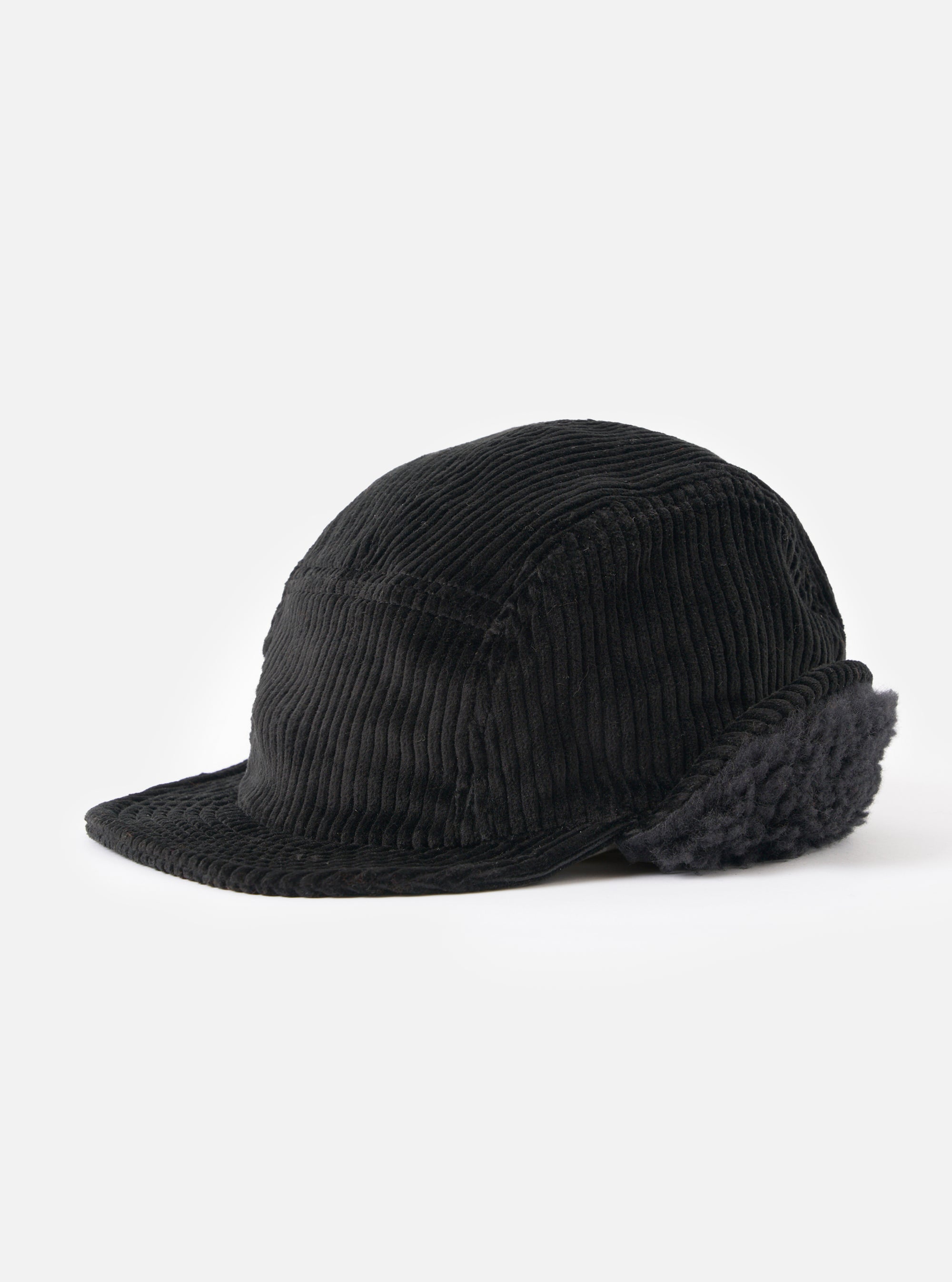 The cableami® Black Corduroy 5w Cap on a white background. The cap is black corduroy with a short brim and ear flaps.