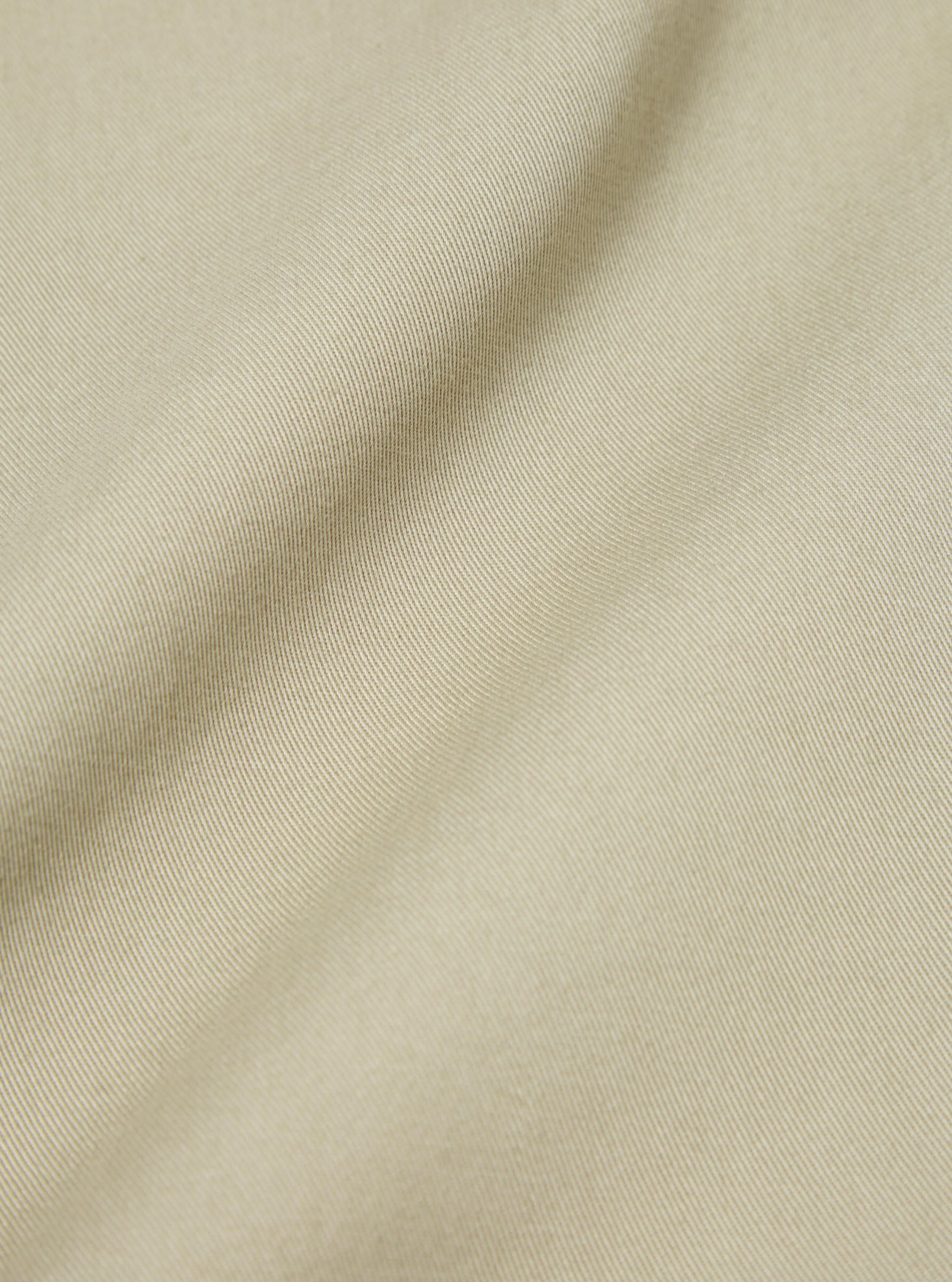 Close-up of the sand twill fabric used for the Fatigue Pant (Undarted). The texture and color are highlighted on a plain background.
