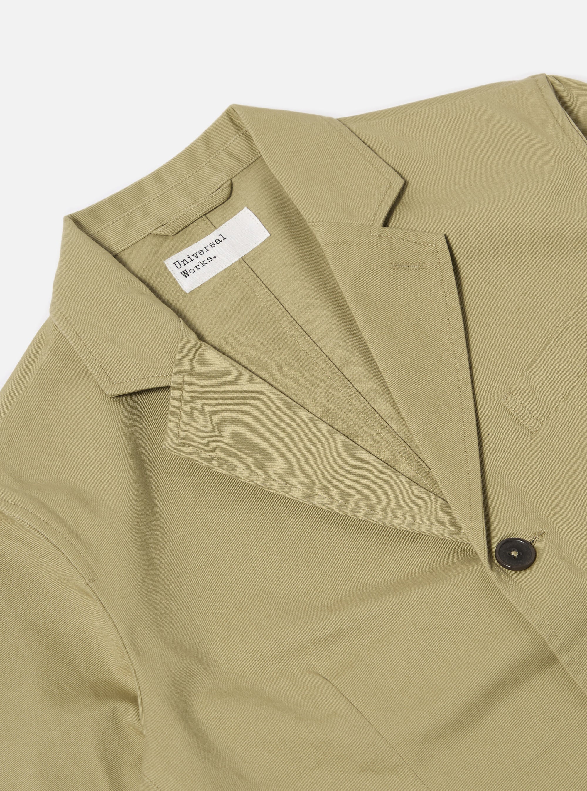 Close-up of the Sand Twill London Jacket on a white background. The jacket is made of a sand-colored twill fabric and has a classic fit. The jacket is buttoned and has a label.