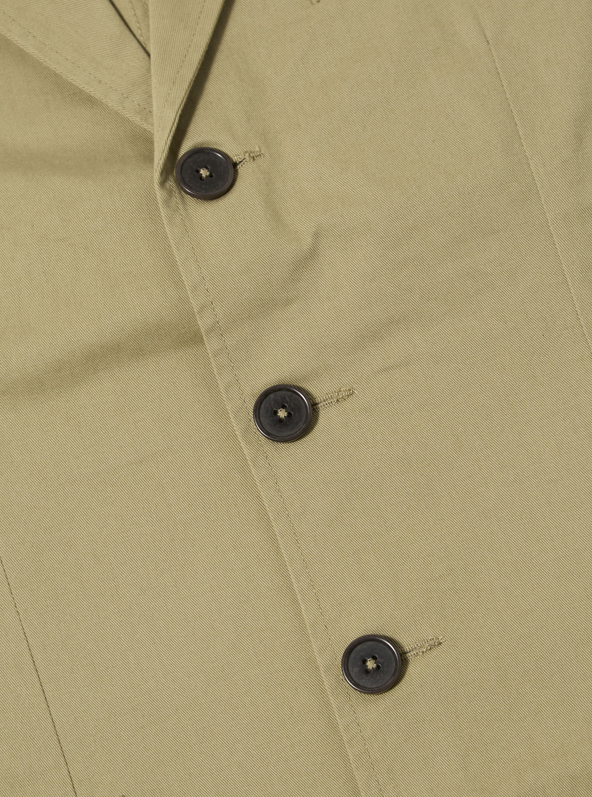 Close-up of the sand twill London jacket, showcasing its textured fabric and button details. The jacket is laid flat on a neutral surface.