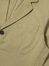 Close-up of the sand twill London Jacket, showcasing its fine twill texture, tailored fit, and dark button. The jacket is displayed on a flat surface.