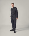 A model stands against a neutral backdrop wearing a Navy Twill Bakers Jacket and matching trousers. The jacket is buttoned and has a relaxed fit.