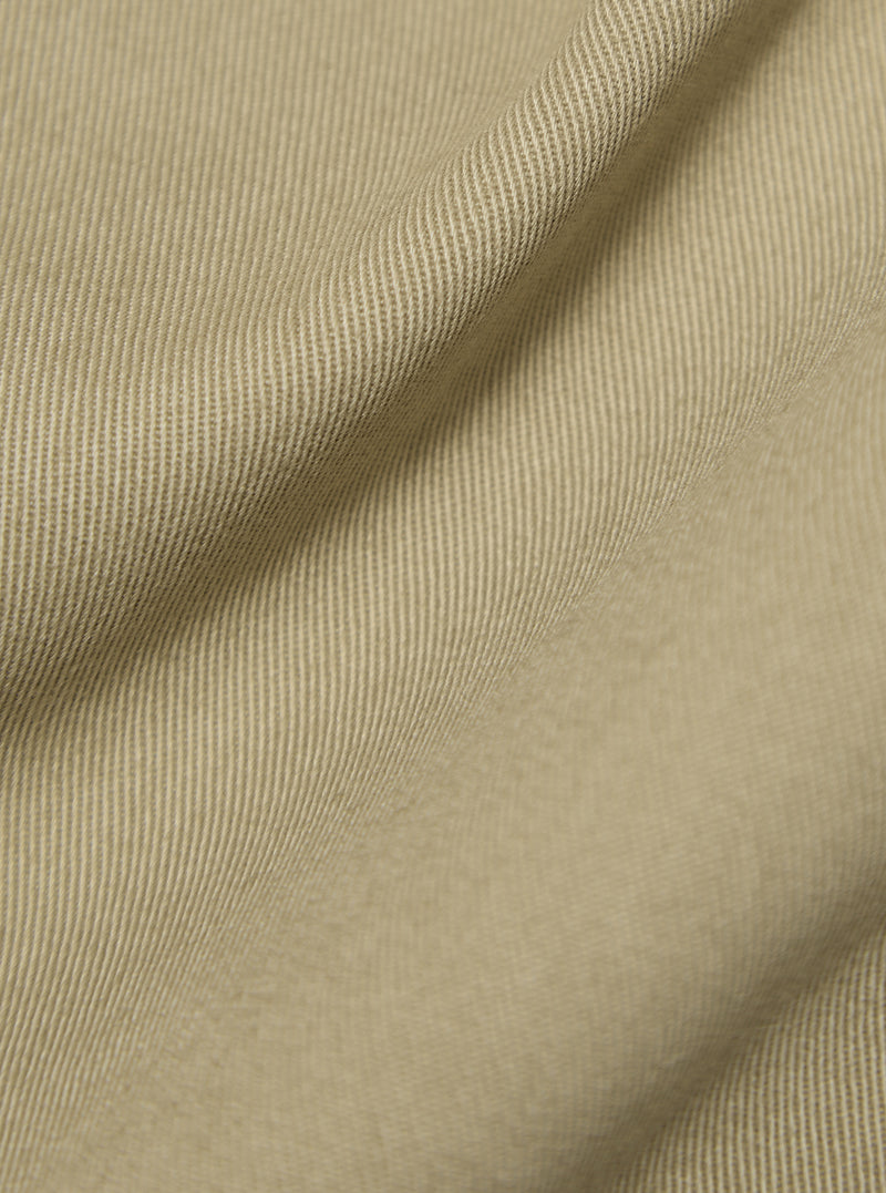 Close-up of the sand-colored twill fabric of the Sand Twill Bakers Jacket, showing texture and drape. Studio shot.