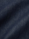 Close-up of the Indigo 13oz Selvedge Denim Bakers Jacket, showcasing the rich indigo color and textured selvedge denim material. The jacket is laid flat on a neutral surface.