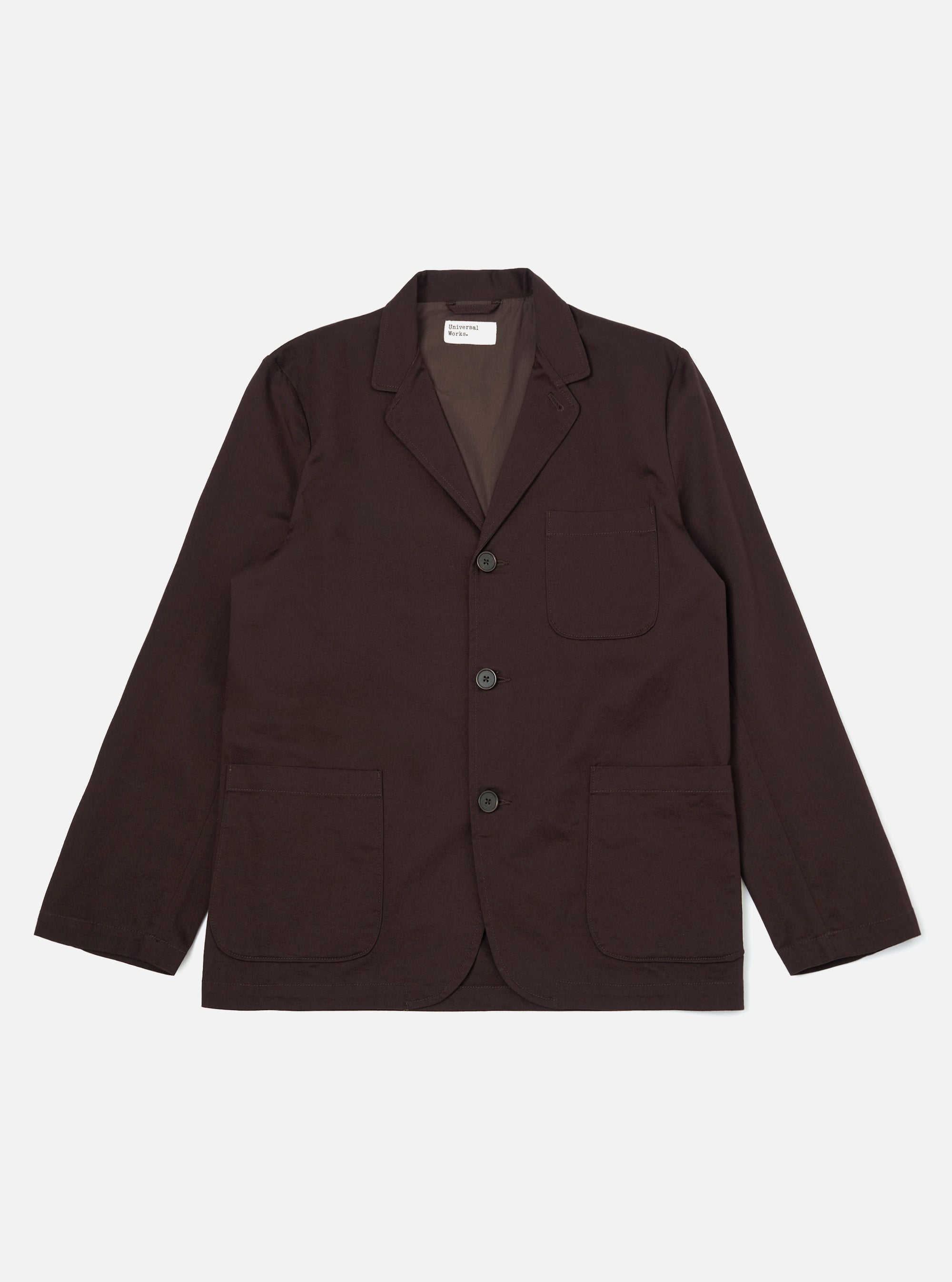 A Brown Twill Three Button Jacket is displayed laid flat against a plain white background. The jacket features a three-button front closure, a notched lapel, and three patch pockets on the front.