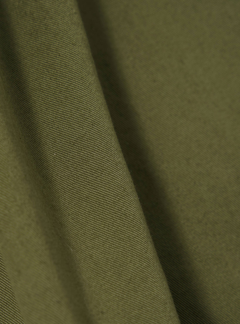 Close-up of the light olive twill Kyoto work jacket fabric. The twill weave is visible, showing the texture and color of the material.