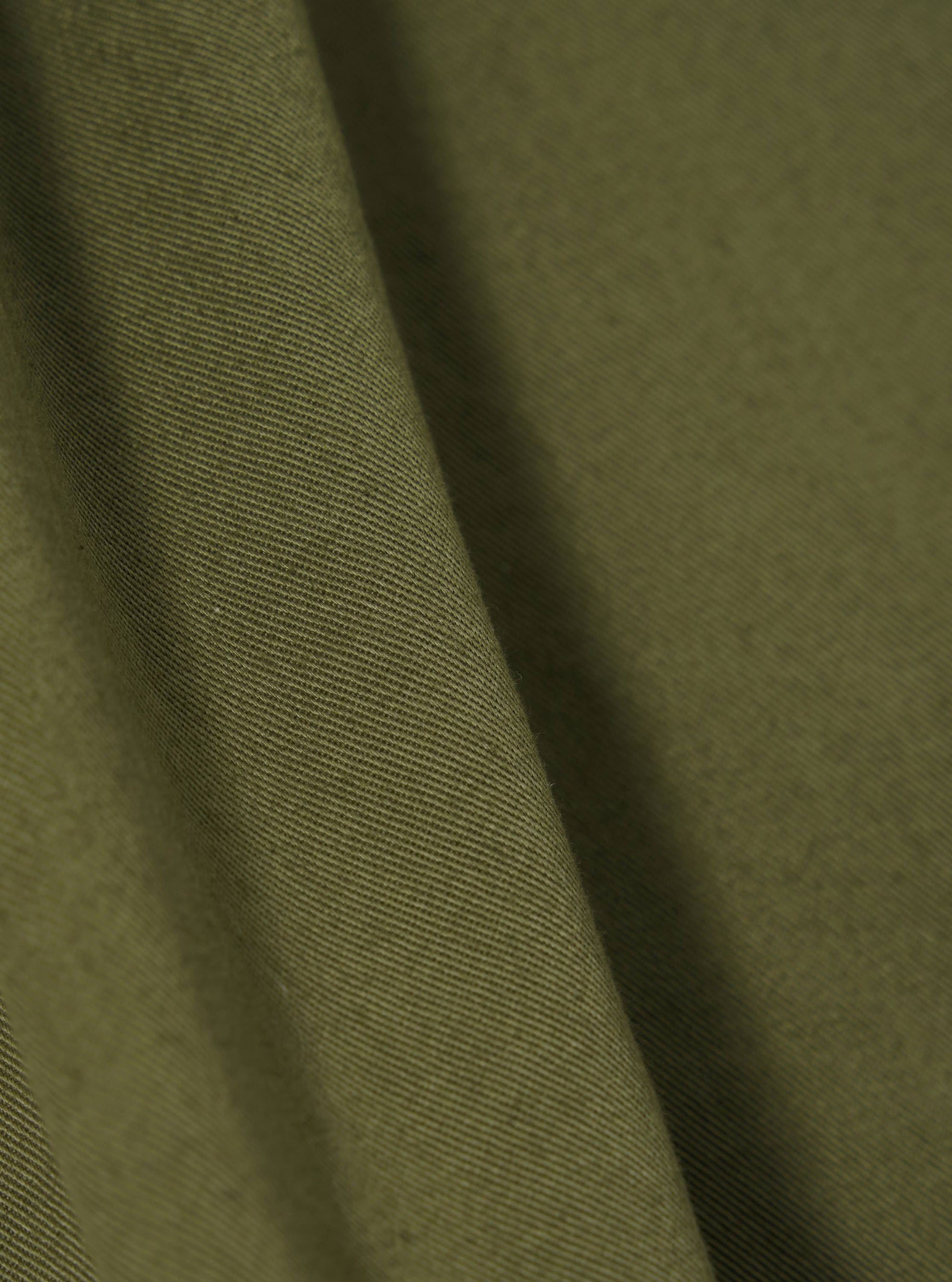 Close-up of the light olive twill Kyoto work jacket fabric. The twill weave is visible, showing the texture and color of the material.