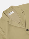 Close-up of the Sand Twill Three Button Jacket on a white background. The jacket is a light tan color and made of twill fabric. The jacket is partially buttoned.