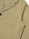 Close-up of the sand twill three button jacket on a white background. The jacket has a pocket and dark button.