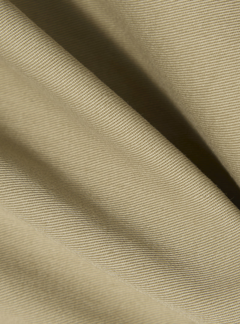 Close-up of the sand twill fabric of the Three Button Jacket. The material is draped to show texture and color. The background is a plain white surface.