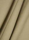 Close-up of the sand twill fabric of the Kyoto Work Jacket, showing the texture and color. The material is draped to highlight its quality.