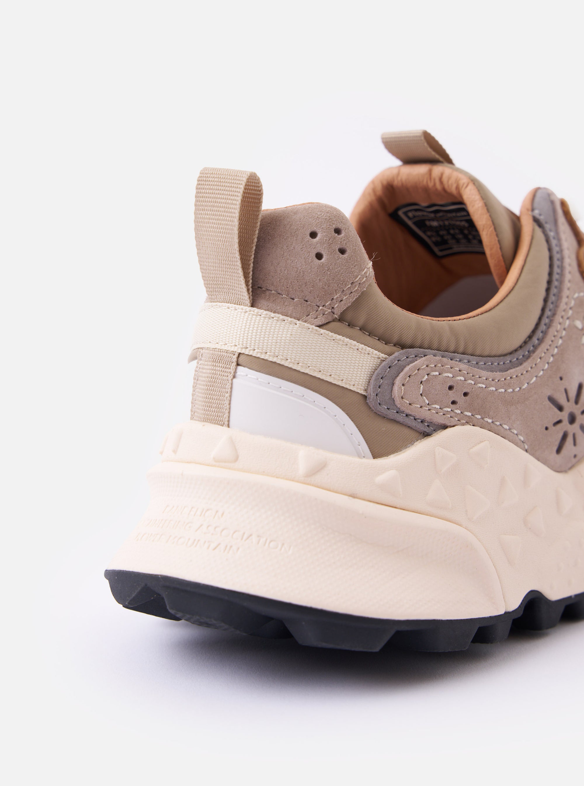 The Flower Mountain Light Brown Suede/Nylon Rulis Uni is shown from a rear angle as a flat lay against a plain white background. The image highlights the light brown suede and nylon upper, the webbing back pull tab, and the thick, off-white notched rubber sole with a contrasting tan insert.