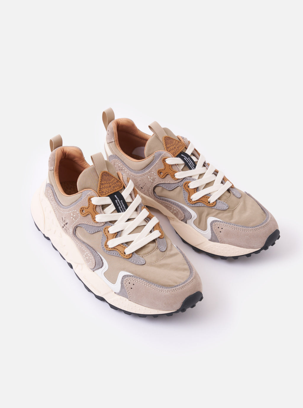 The Flower Mountain Light Brown Suede/Nylon Rulis Uni is shown from the back as a flat lay against a plain white background. The image highlights the rear of the sneaker, featuring a light brown suede heel counter, a brown webbing back pull tab, and the notched edge of the rubber gum sole.