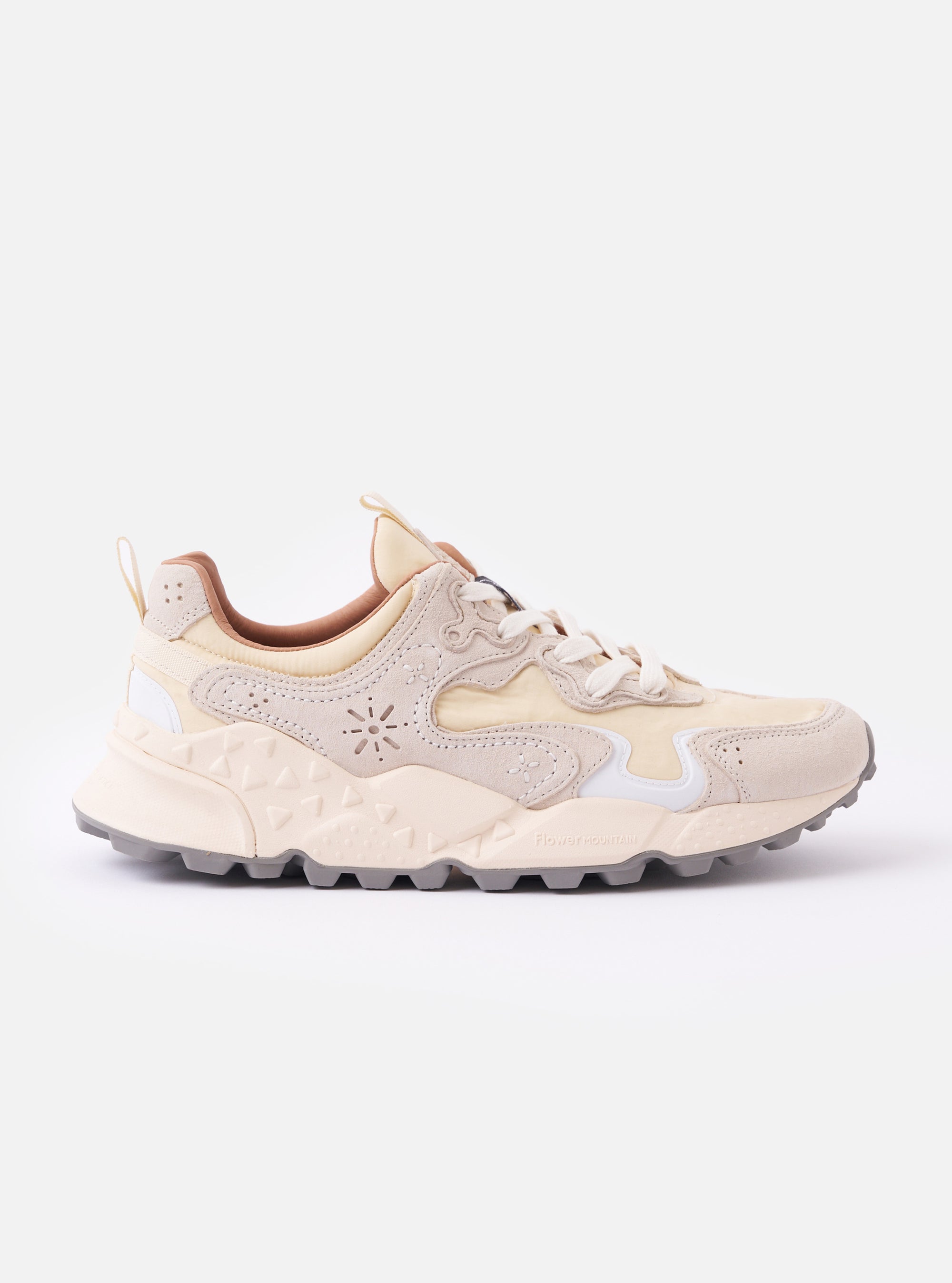 The Flower Mountain Milk/Light Beige Suede/Nylon Rulis Uni is shown as a flat lay against a plain white background. The sneaker features a technical nylon upper with overlapping light beige suede panels and a contrasting white rubber sole with a textured, indented tread. The design includes cream-colored cotton laces, reinforced eyelets, and a webbing pull tab at the heel.