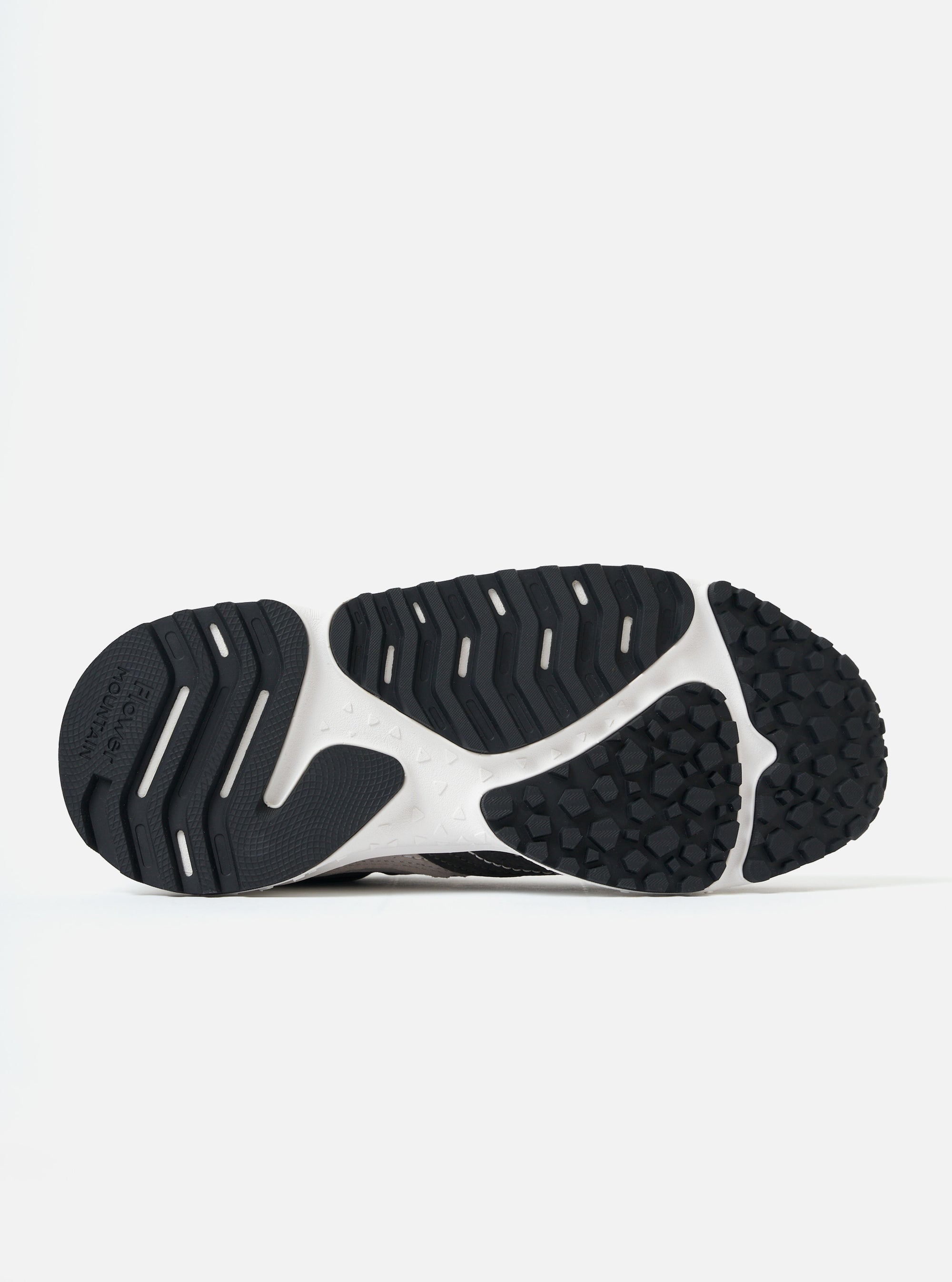 Close-up of the sole of a Flower Mountain Light Grey/Dark Grey Suede/Nylon Wave Man shoe on a white background. The sole is black and white with a geometric pattern.