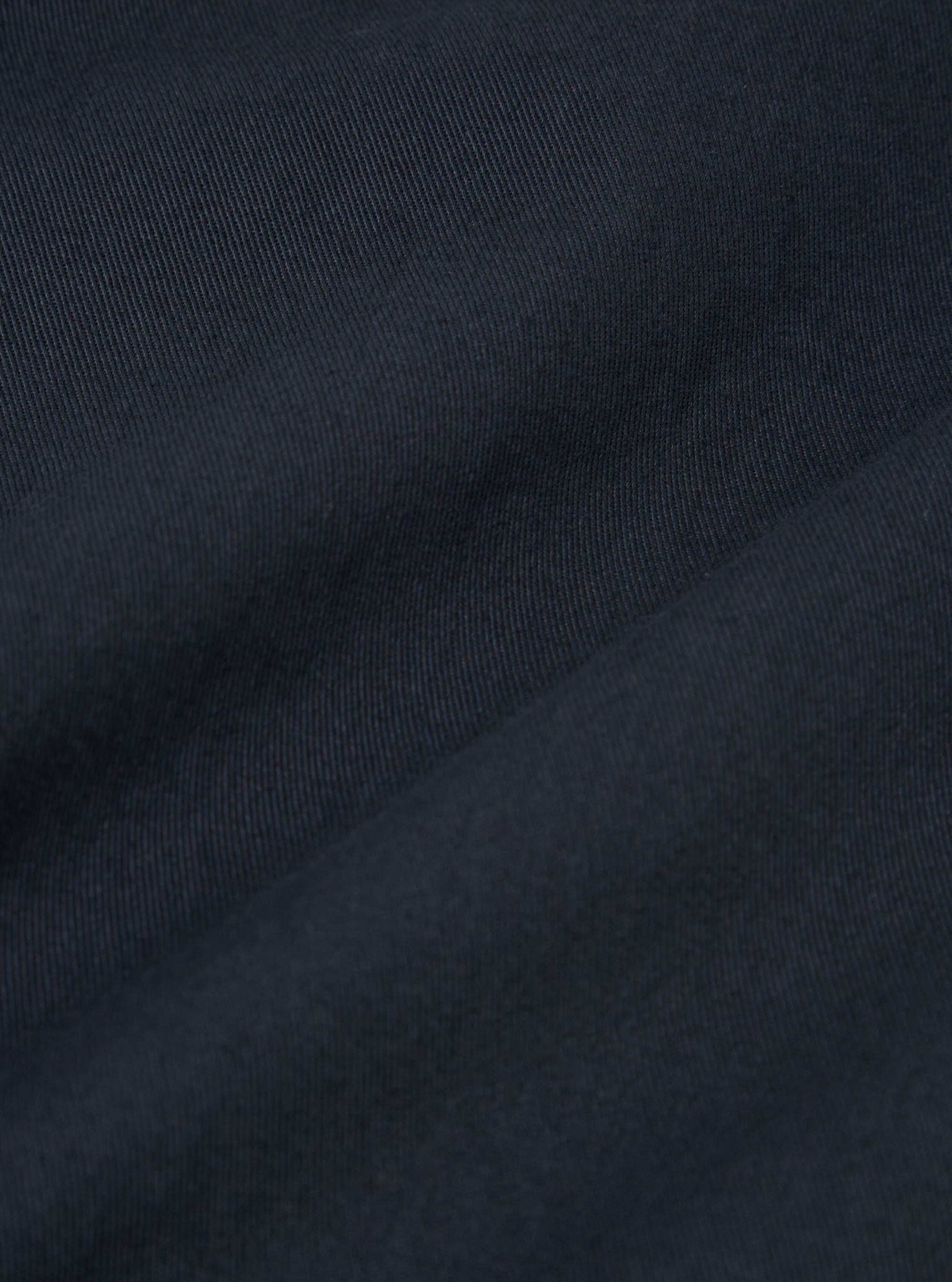 Close-up of the Navy Twill Military Chino fabric. The dark blue twill weave is clearly visible, showing the texture and quality of the material.