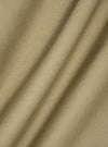 Close-up of the sand twill double pleat pant fabric. The material is draped to show texture. The background is a plain white surface.