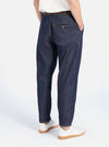 Back view of a model wearing Indigo 13oz Selvedge Denim Military Chino, dark blue denim pants with a relaxed fit. Shot in a white studio with white sneakers.