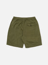 The Light Olive Twill Beach Short is shown from the back in a flat lay position against a plain white background. The shorts feature a single rear patch pocket on the right side with a button-down flap and a visible orange label. The elasticated waistband is visible at the top.