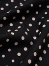 Close-up of a draped Black Dot Print Short Scarf. The scarf has a black background with small, light pink polka dots. The fabric is softly folded.