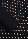 Close-up of a Black Dot Print Short Scarf with fringe. The scarf has white dots and the words "universal works."