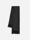 Draped on a white surface, a Black Dot Print Short Scarf. The black scarf features small white dots and a fringed edge. The brand name is printed near the bottom.