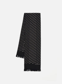 Draped on a white surface, a Black Dot Print Short Scarf. The black scarf features small white dots and a fringed edge. The brand name is printed near the bottom.