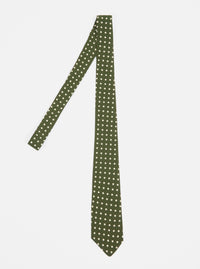 The Olive Dot Print Tie is displayed on a white background. The tie is olive green with small white dots. The tie is made of silk and has a classic fit.