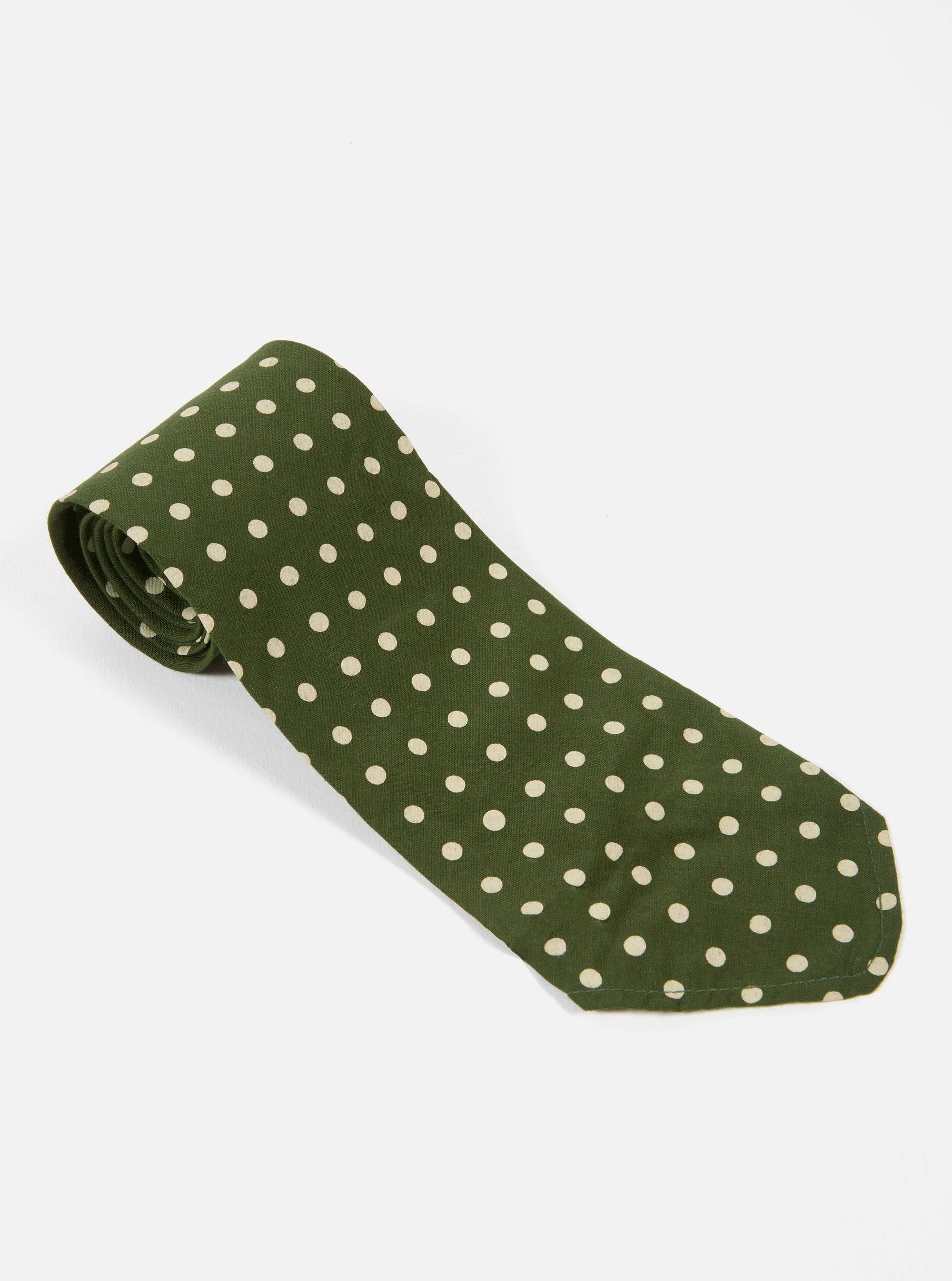 The Olive Dot Print Tie on a white surface. The tie is olive green with small white dots. The tie is rolled up at the top.