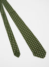 The Olive Dot Print Tie on a white background. The tie is olive green with small white dots. The tie is made of a soft, silky material.