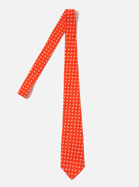 The Orange Dot Print Tie is displayed on a white background. The tie is orange with white dots. The tie is made of silk.