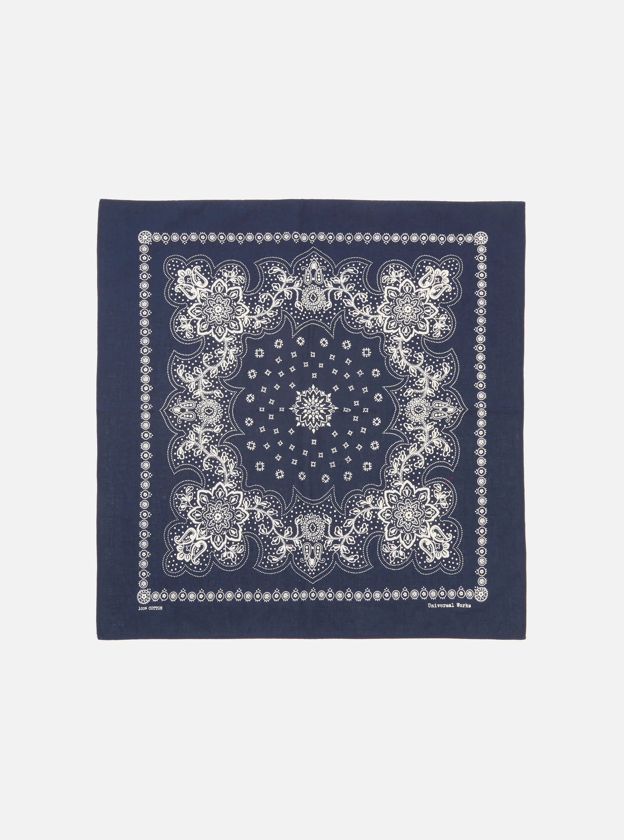 Flat lay of a Navy Classic Bandana Neckerchief on a white background. The bandana is navy with a white floral pattern. 100% cotton.