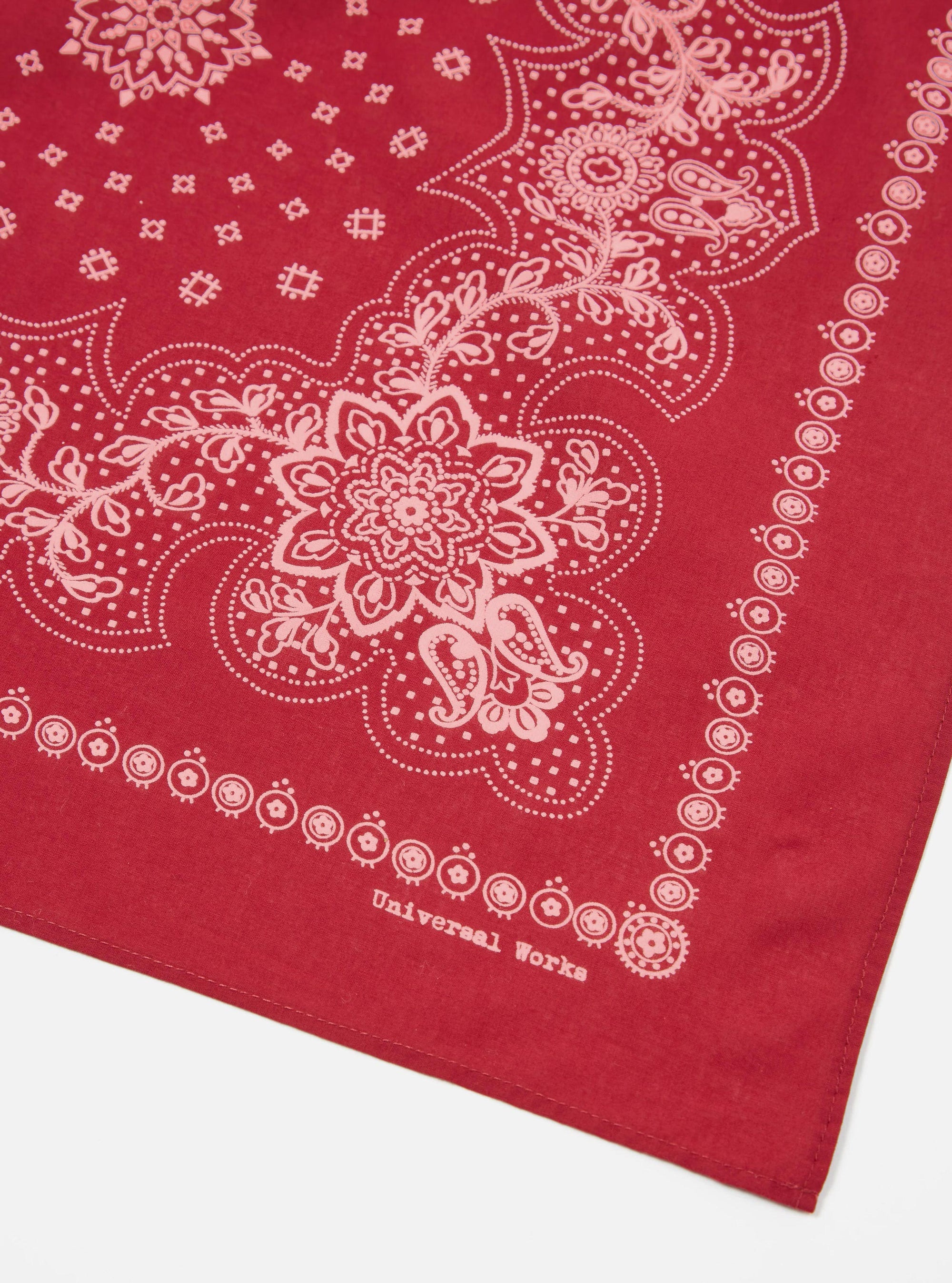 Close-up of a Red Classic Bandana Neckerchief on a white surface. The bandana has a paisley pattern.