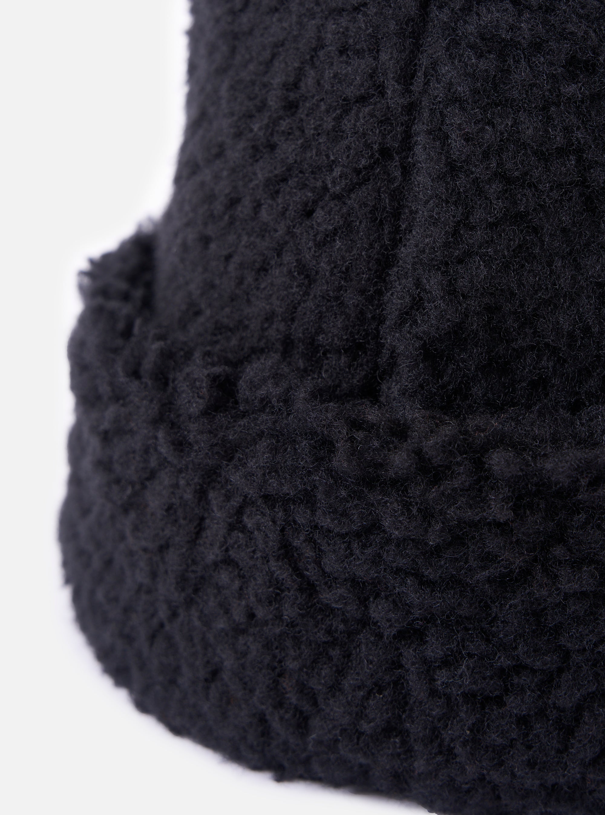 Close-up of the cableami® Black Toque Boa Cap, showcasing its soft, textured material against a clean white background. The image highlights the hat's cozy and stylish design.